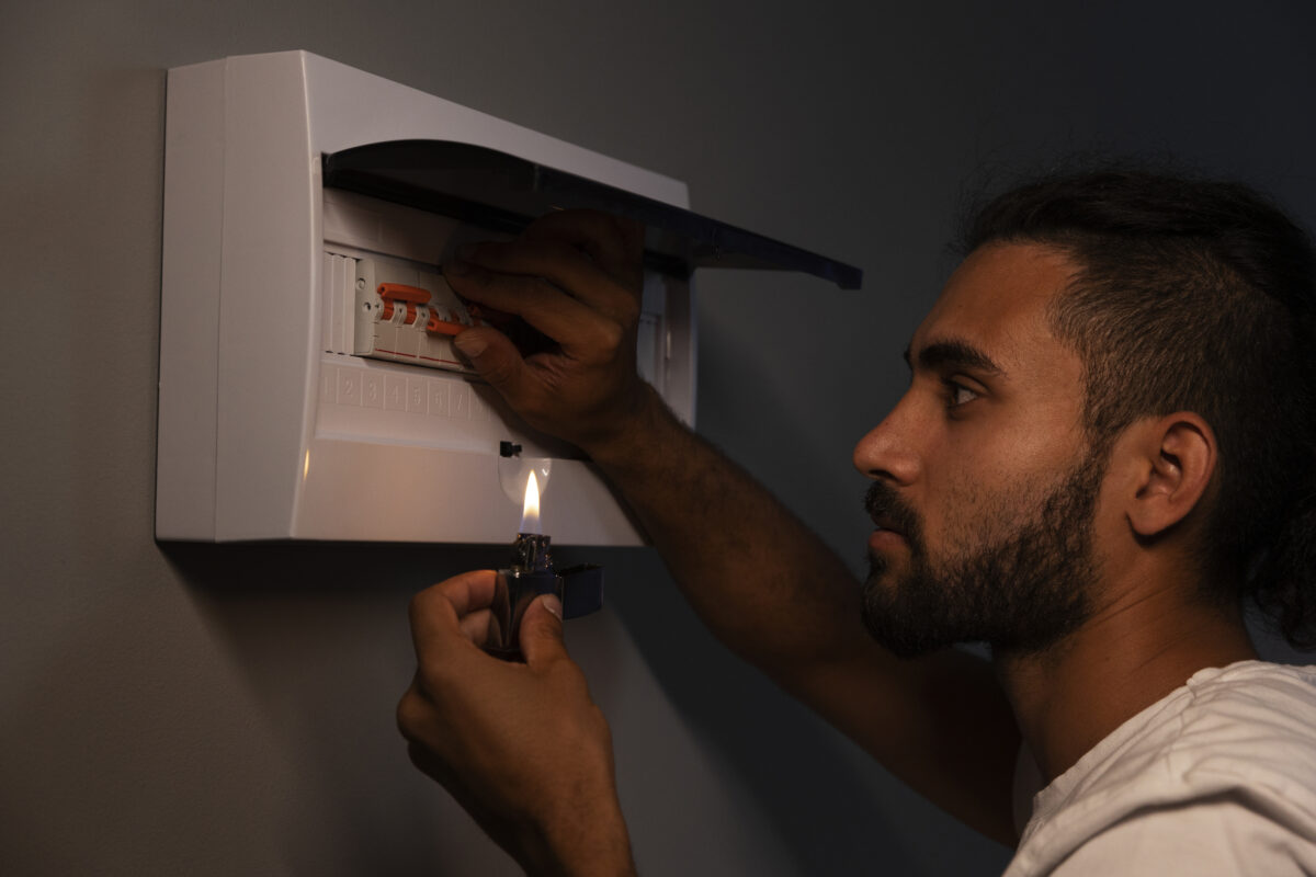 side view man checking electrical panel